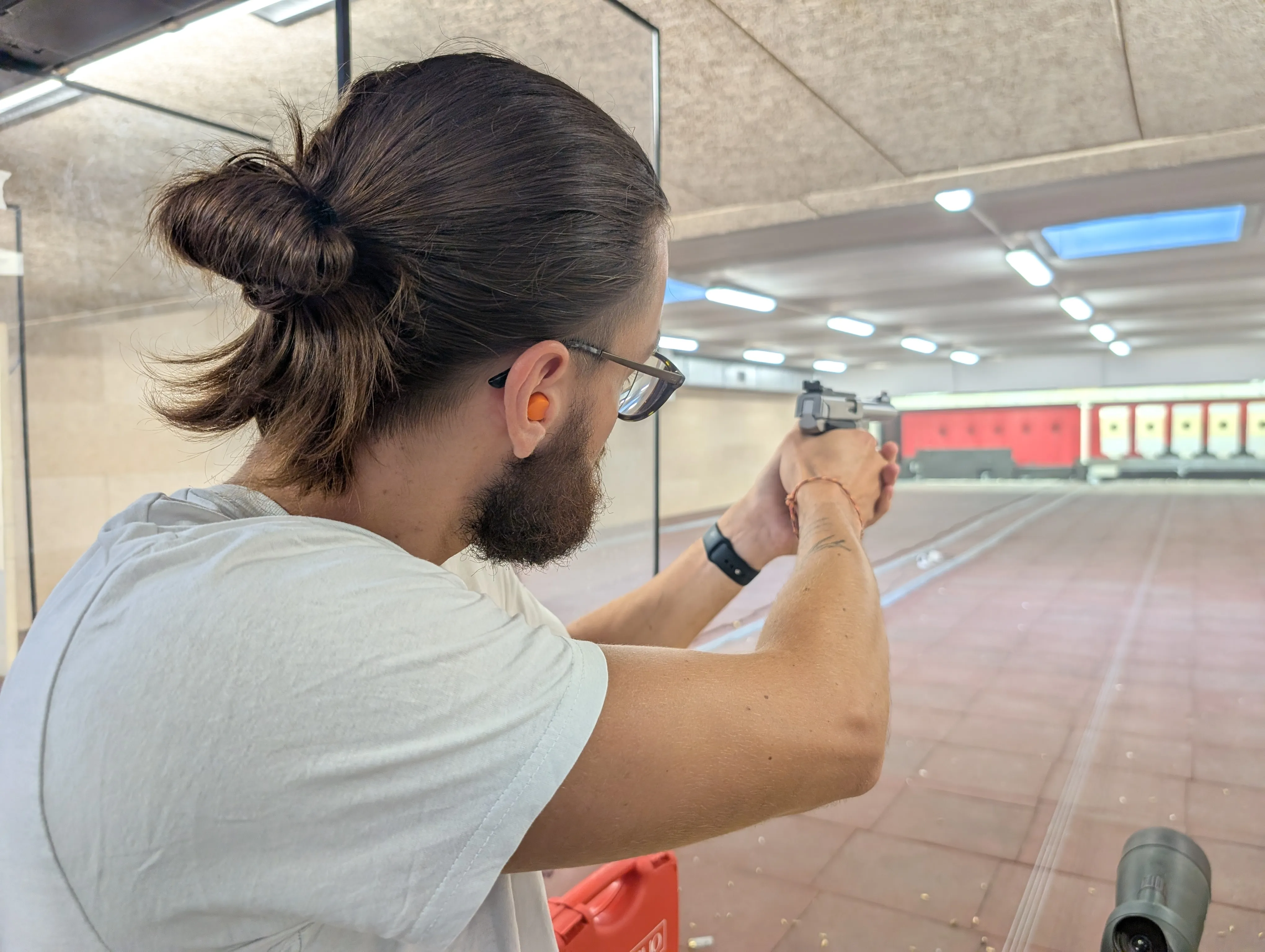 Un adhérent tire au pistolet dans le stand 25 m couvert